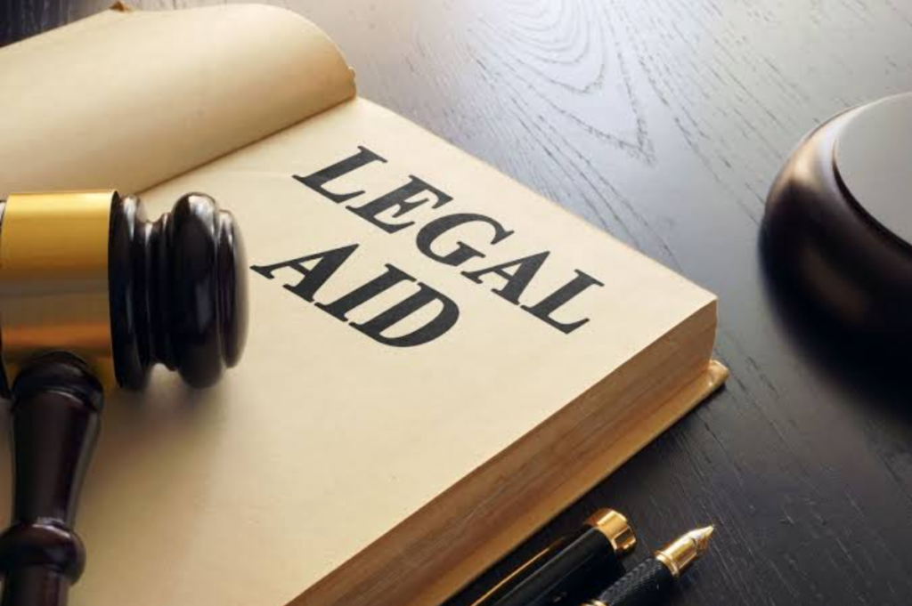 Legal aid book with a judge’s gavel, pen and courtroom items on a desk.