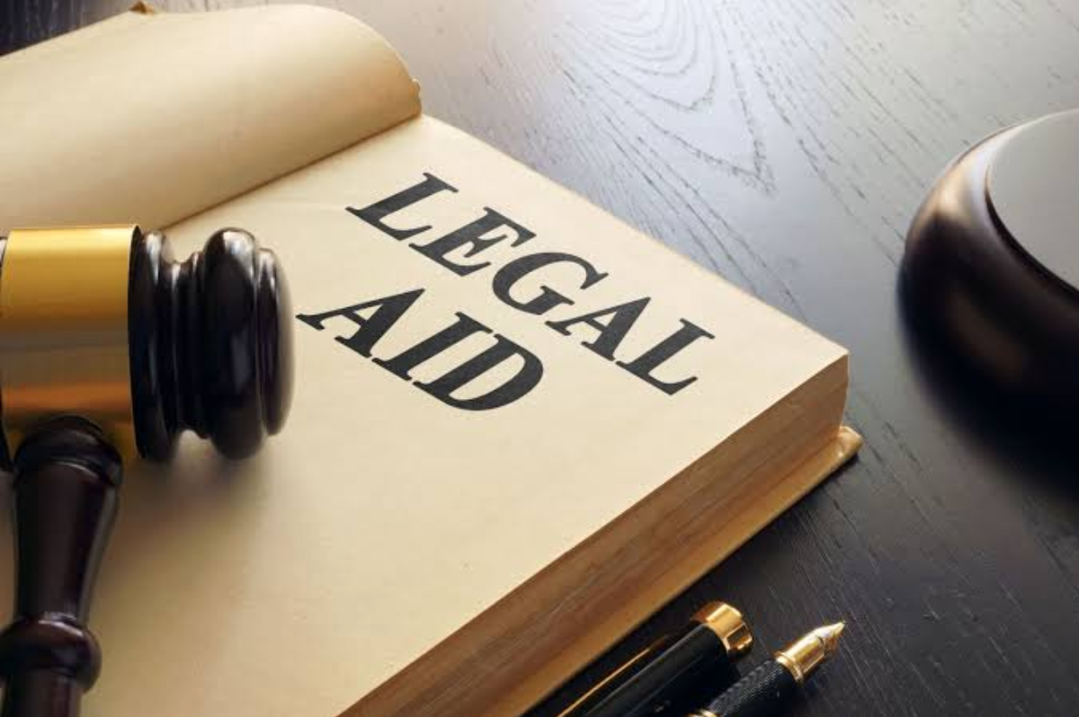 Legal aid book with a judge’s gavel, pen and courtroom items on a desk.